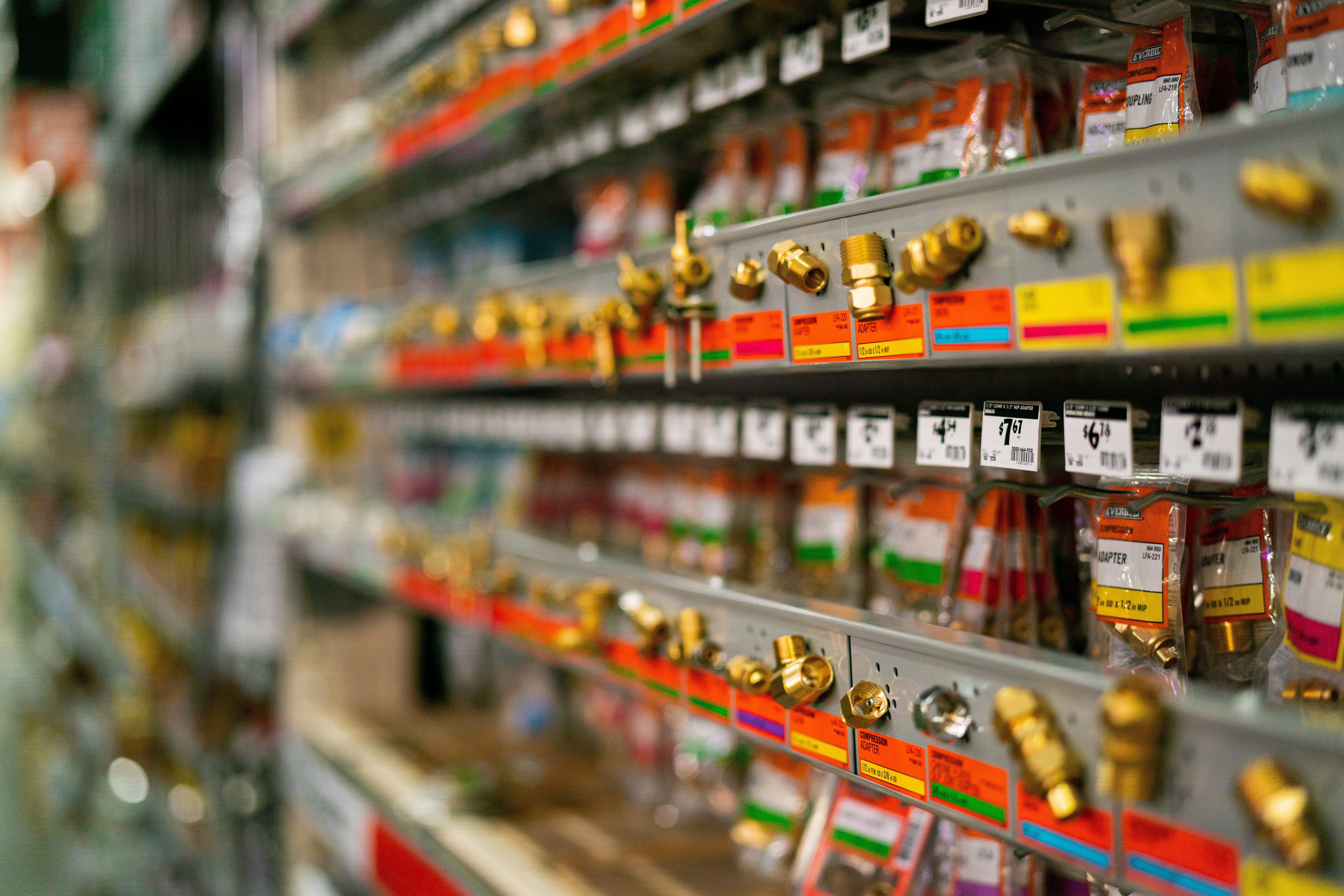Shelves of brass fittings with printed shelf labels